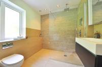 Modernes Badezimmer mit Plattendesign von Sven Zimmermann – Plattenbeläge an Boden und Wänden mit moderner Duschtrennwand aus Glas